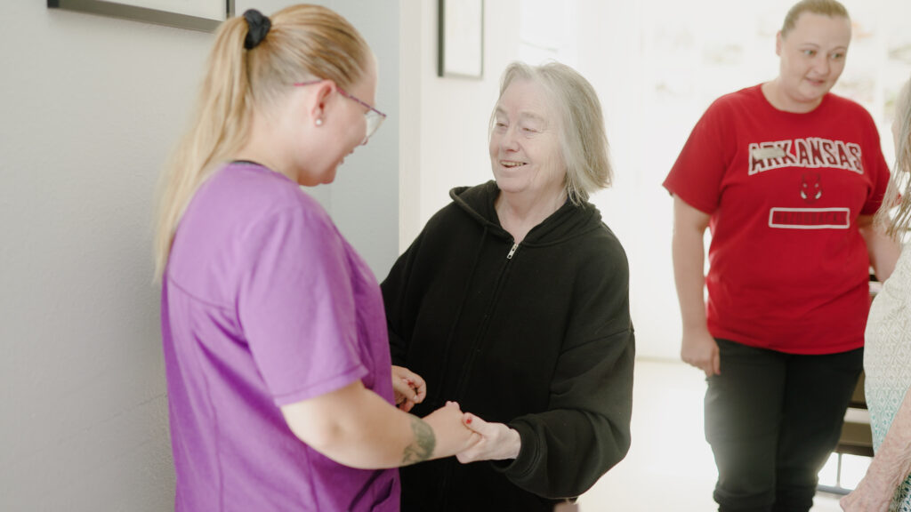 A woman is smiling at a nurse at a skilled nursing facility nursing home