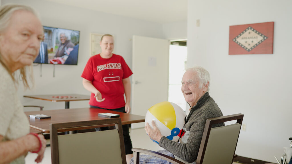 A man smiling at a nurse while doing exercise at a short term care nursing facility