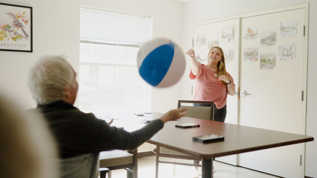A nurse throws a ball to a memory care patient at Eagle Crest a skilled nursing facility
